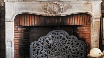 A fireplace with ornate carvings and a decorative metal sculpture.
