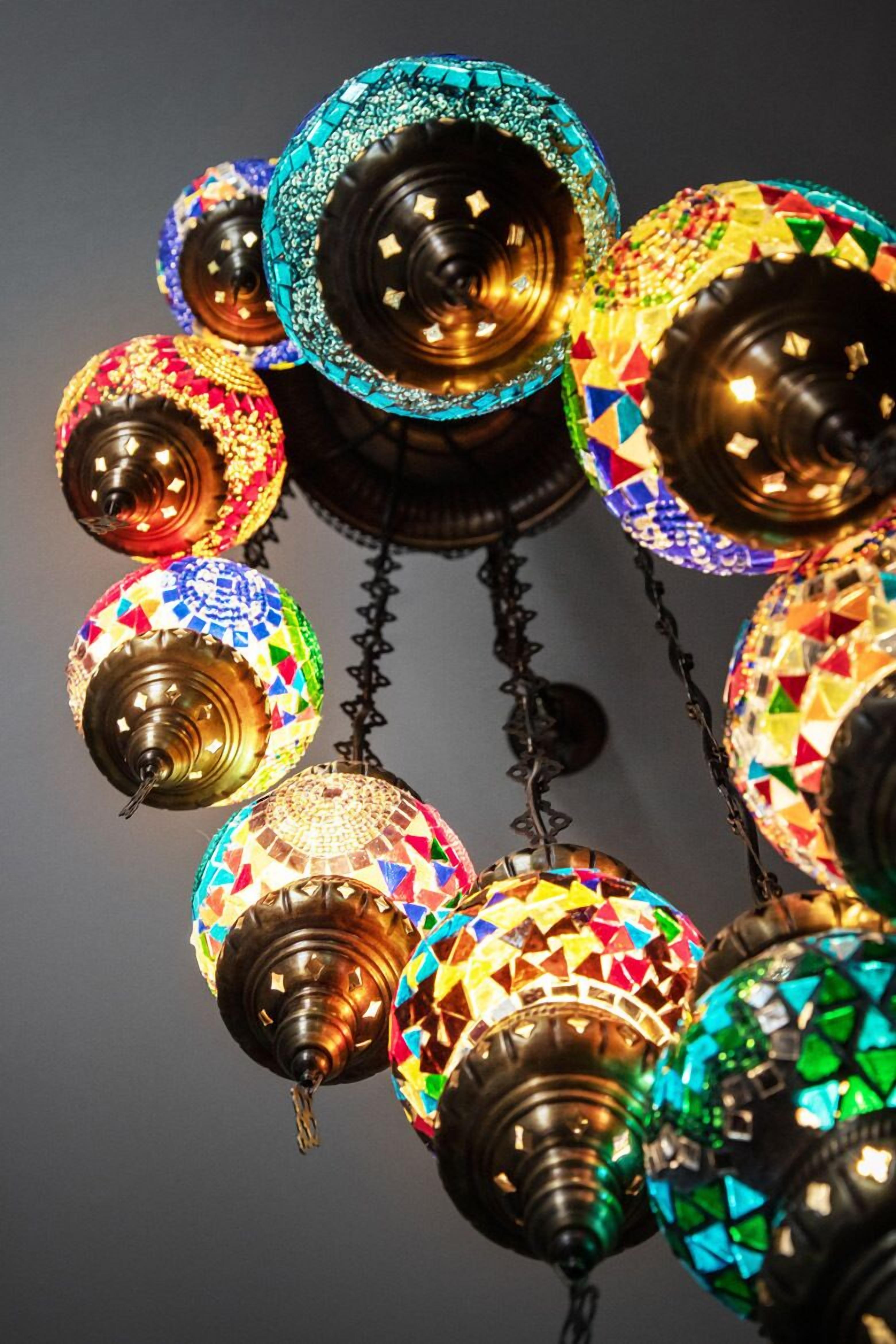 Une série de lampes suspendues aux motifs colorés, créant un effet mosaïque.