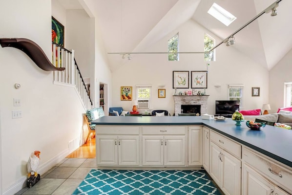 A spacious kitchen with a large island, white cabinetry, and a dining area with a sofa and table.
