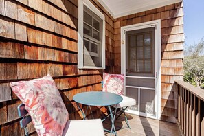 A wooden deck with a table and chairs, a door, and a window. - 5 bedroom Private Family Get Away w/ Heated Pool (Westhampton Beach)