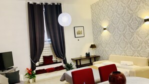A modern living room with a sofa, a dining table, a TV, and a decorative vase. - Chroma Apt Farinone 28 (Rome)