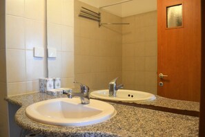 A bathroom with two sinks, a mirror, and a wooden door.