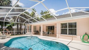 An indoor swimming pool with a glass ceiling, surrounded by lounge chairs and a patio area. - Villa Valk - Comfort - 3 Bedroom (Hernando)