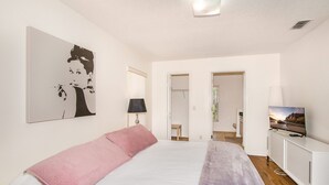 A bedroom with a bed, a TV, a painting, and a wardrobe. - Villa Valk - Comfort - 3 Bedroom (Hernando)