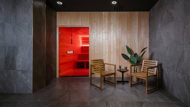 Un interior moderno con dos sillas de madera, una mesita y una planta en maceta.
