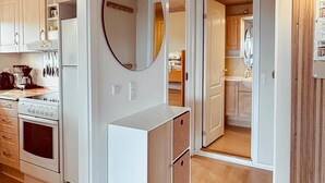 A kitchen with white cabinets, a stove, and a mirror. - 2 bedroom gorgeous apartment in Allinge (Allinge)