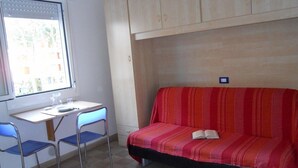 Une chambre avec un lit, un bureau et deux chaises.