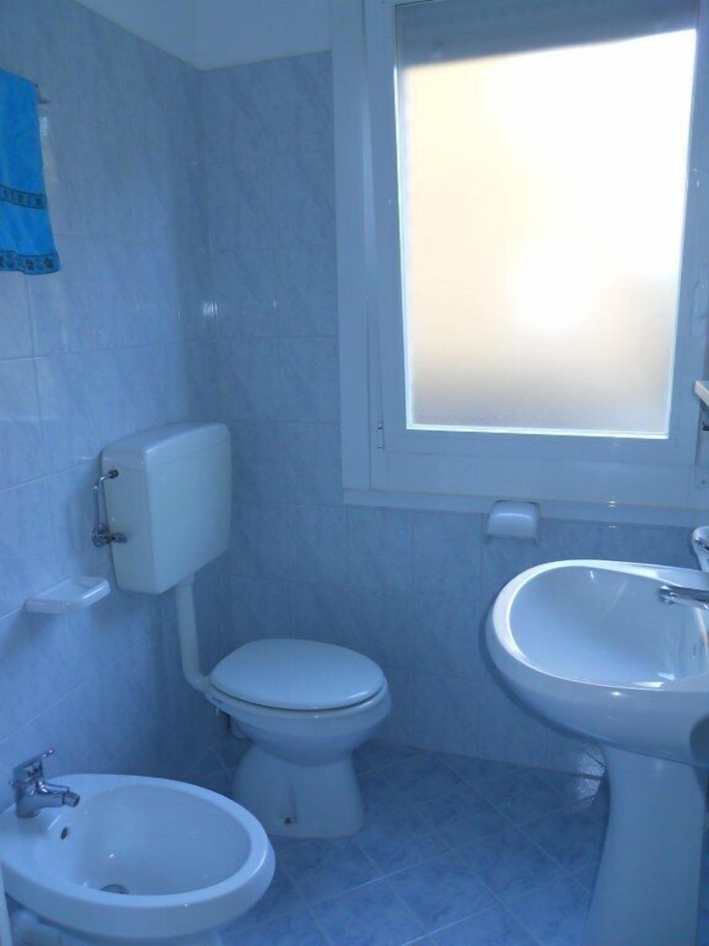 A bathroom with a toilet, bidet, and sink.