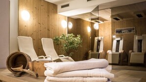 Un espace spa avec des murs en bois, un miroir et plusieurs chaises blanches.