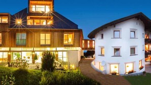 Un hôtel moderne à la structure à deux étages, doté de grandes fenêtres et d’un espace extérieur bien éclairé, aménagé avec des sièges.