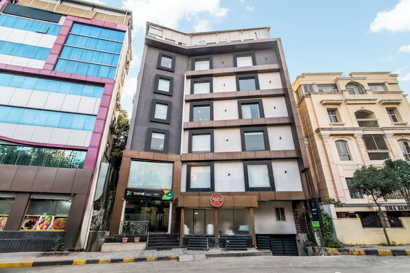 A multi-story building with a restaurant named 'Aura' on the ground floor, featuring a sign with a circular logo. - Treebo Address Inn, Banjara Hills (Hyderabad)