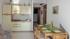 Una cocina compacta con comedor, que incluye una mesa con individuales y sillas.