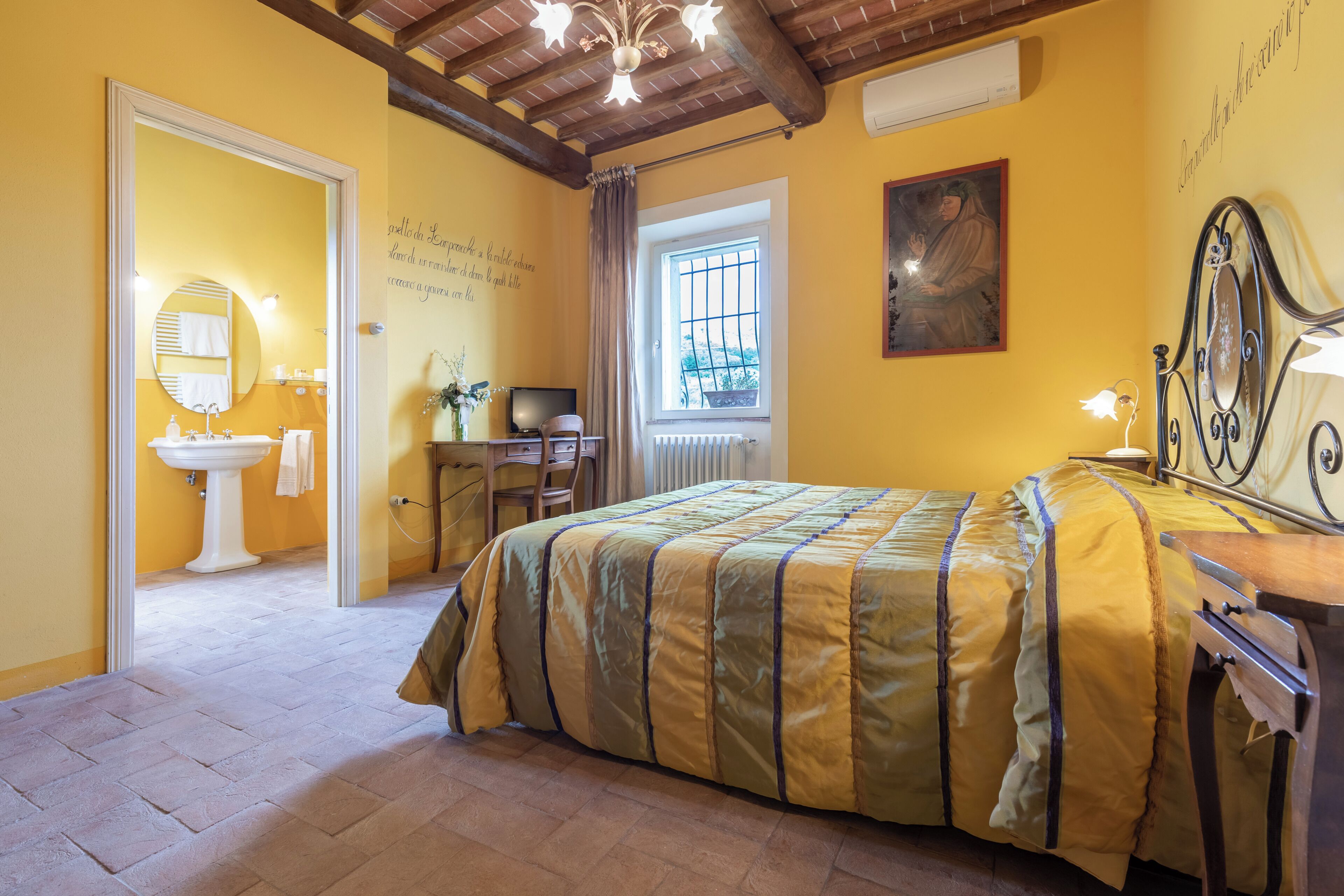 Un dormitorio con cama, escritorio, silla, ventana, espejo y radiador.