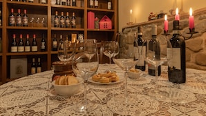 A table with wine glasses, bottles, and pastries on a lace tablecloth. - La Casa Medioevale B&B (Lamporecchio)