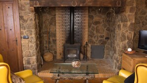 Una sala de estar acogedora con chimenea de piedra, sillones de cuero amarillo y una mesa de centro de vidrio.
