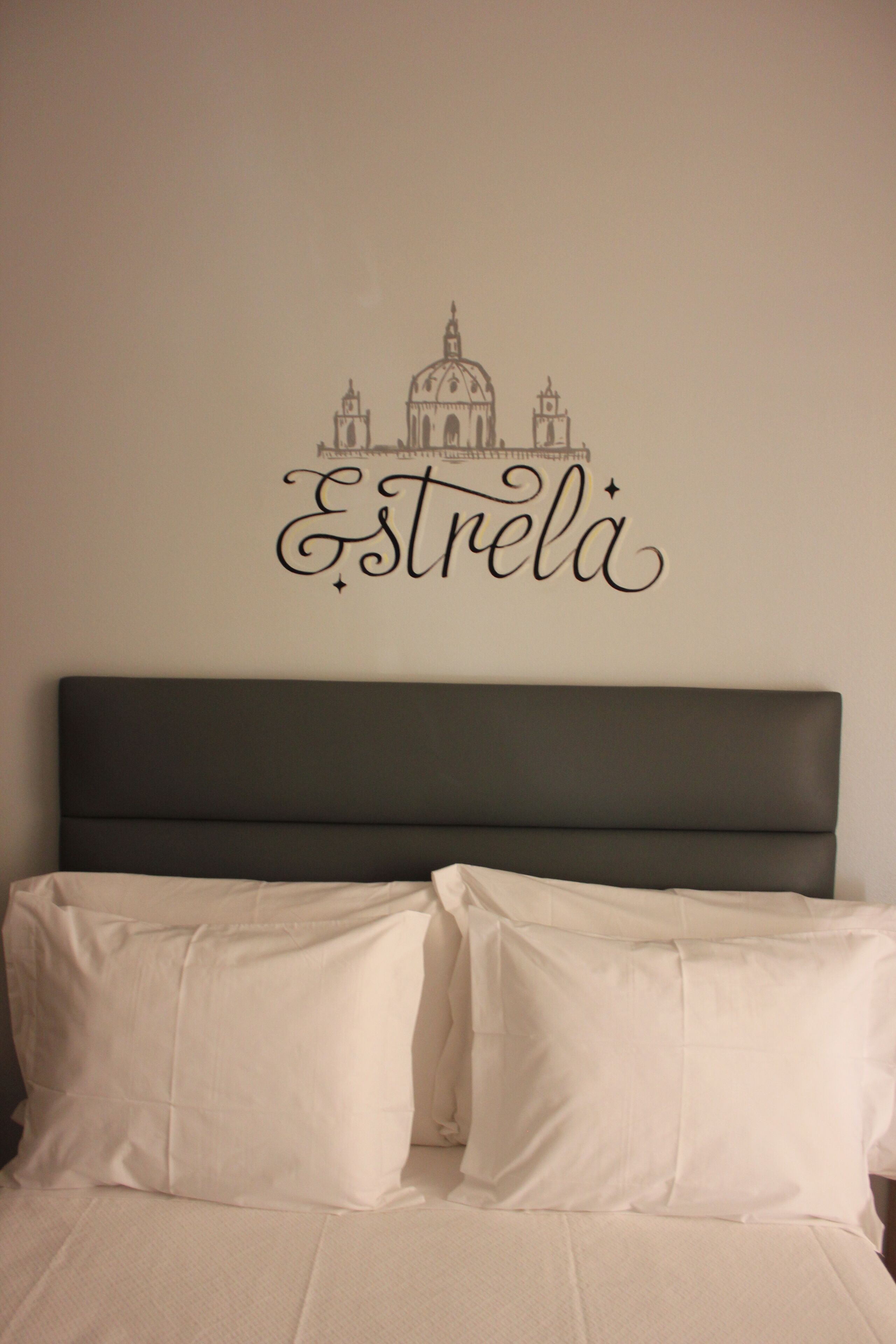 A bed with two white pillows and a dark headboard.