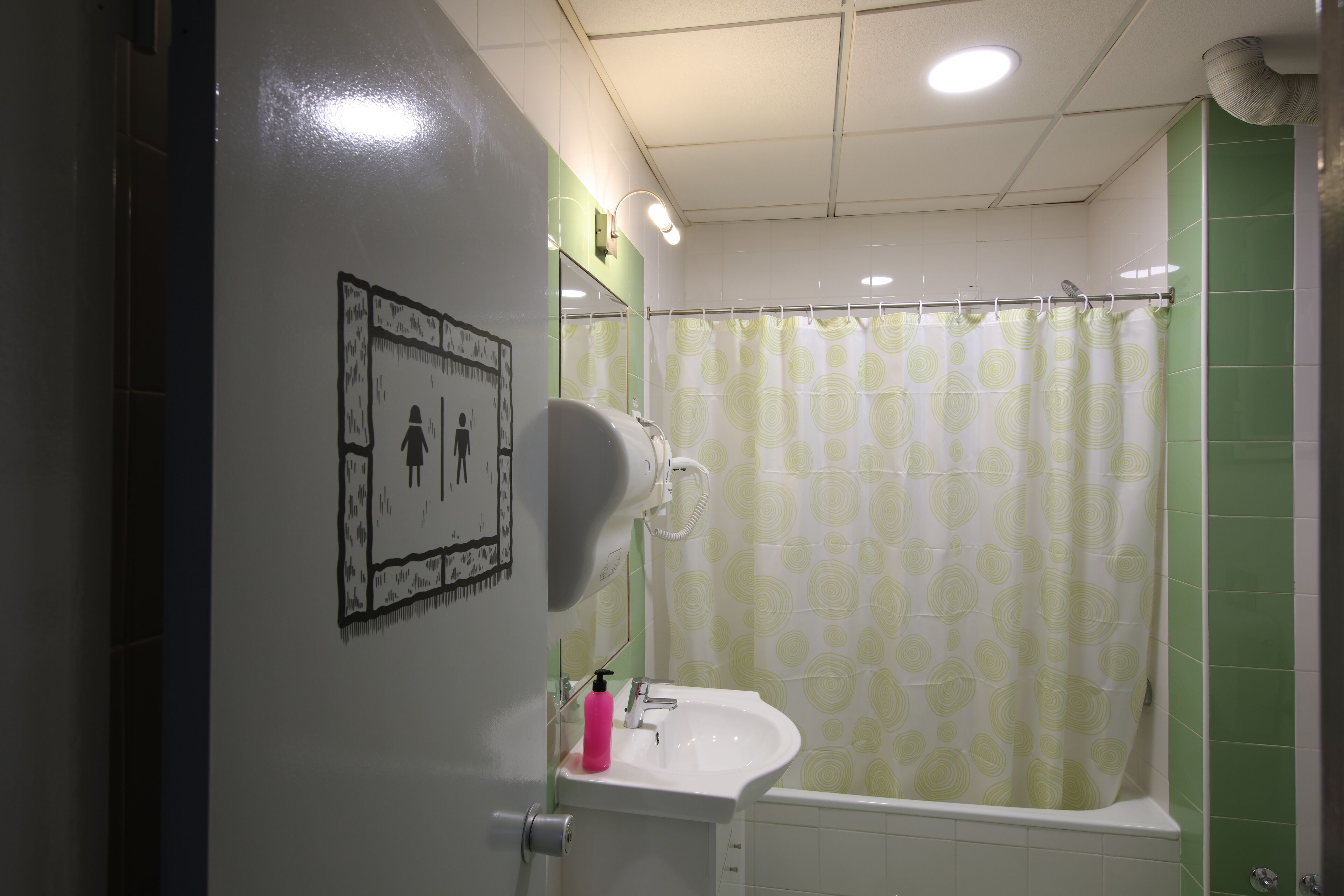 A bathroom with a sink, mirror, and shower curtain.
