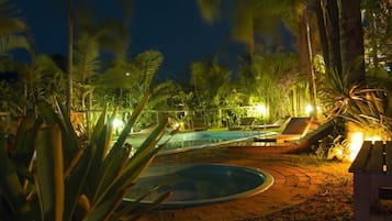 Una piscina al aire libre, sillones reclinables de piscina