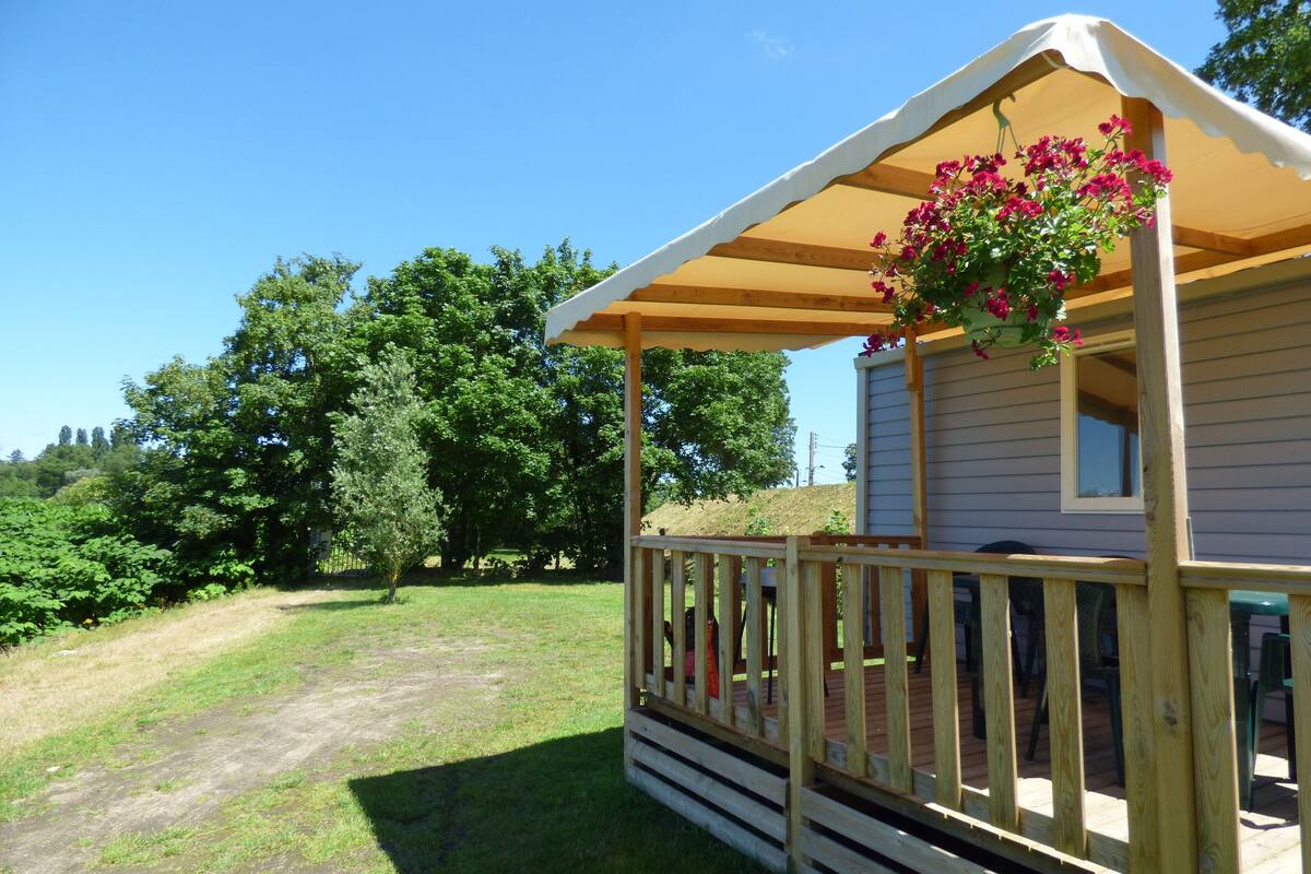 A small cabin with a wooden deck and a covered porch.