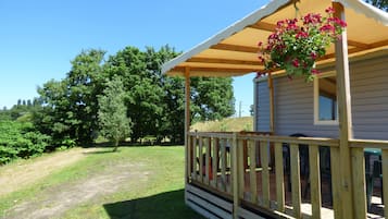 A small cabin with a wooden deck and a covered porch.