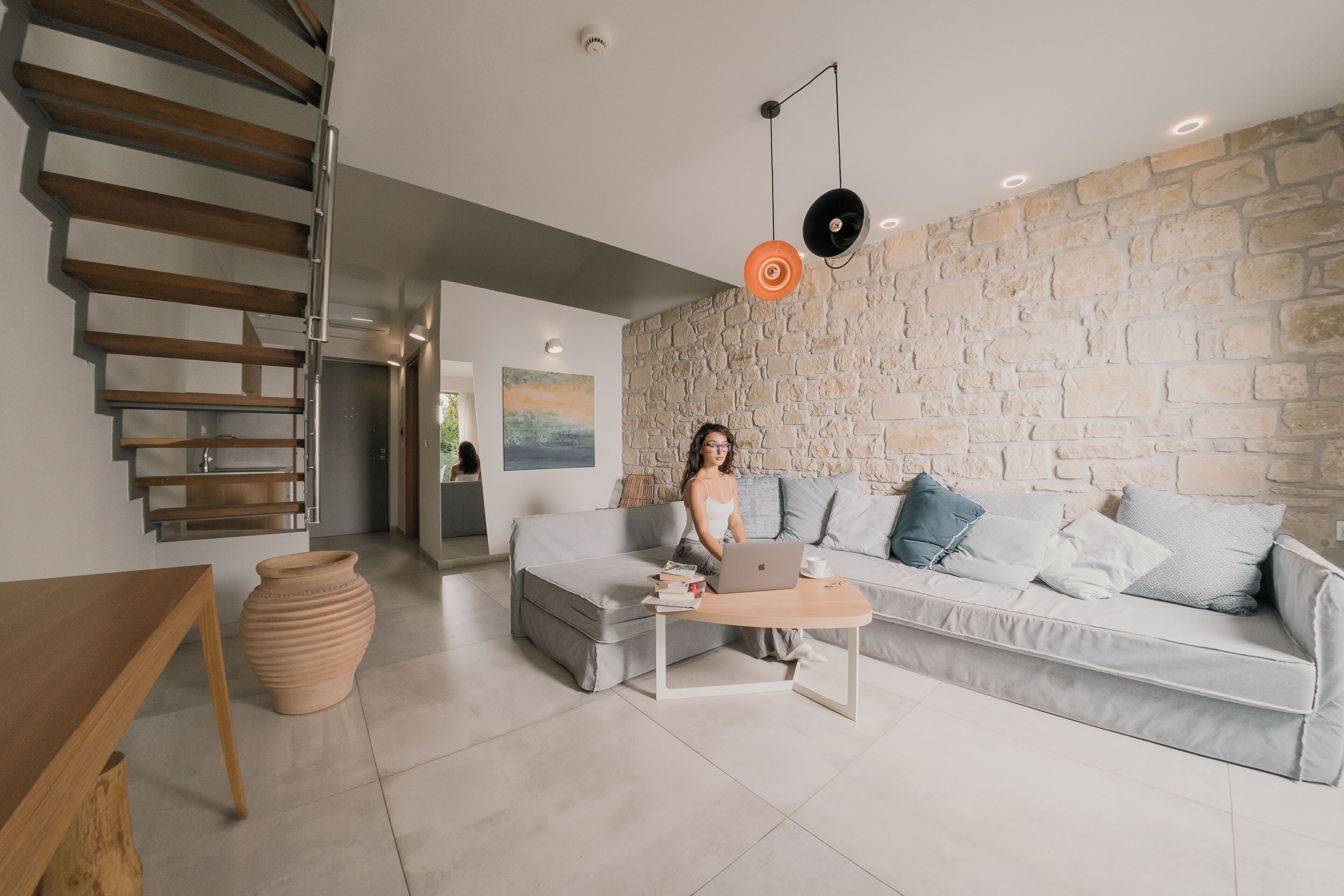 Un salon moderne avec un canapé, une table basse et un ordinateur portable.