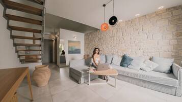 Un salon moderne avec un canapé, une table basse et un ordinateur portable.