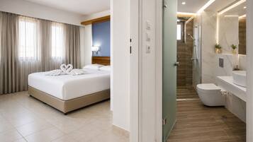 Une chambre d’hôtel avec un lit, une salle de bain avec douche et des toilettes.