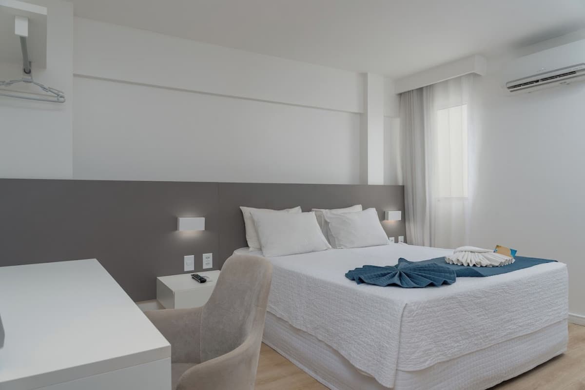 Een moderne hotelkamer met een groot bed, een bureau en een stoel.