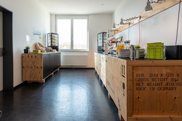 A modern kitchen with a large window, wooden cabinets, and a built-in bread display.