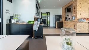 A modern kitchen area with a wooden counter, a glass jar with flowers, and a sign that reads "YOUR DAILY SOUP". - a2 HOTELS DENKENDORF (Denkendorf)