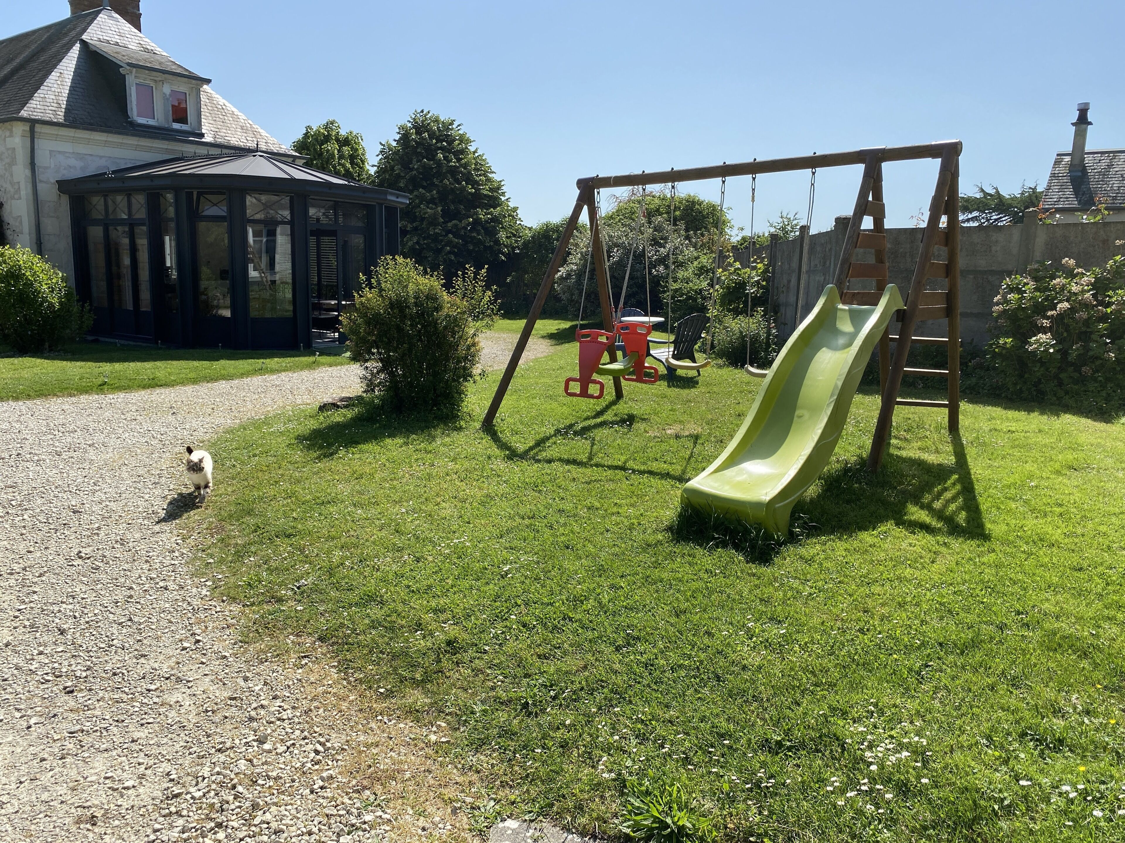 A backyard with a swing set and a slide.