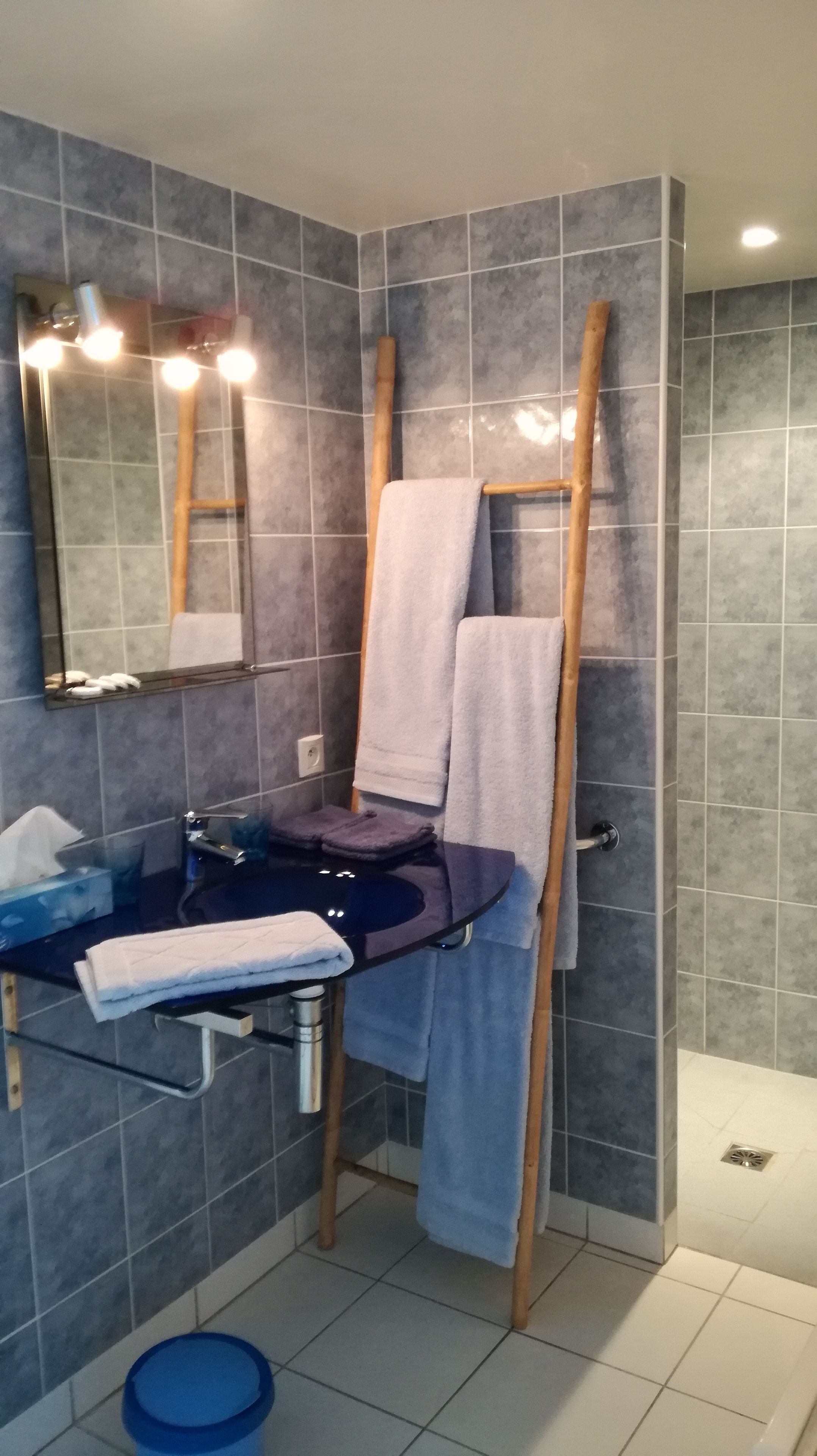 A bathroom with a mirror, sink, and towel rack.