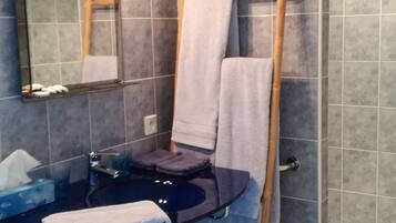 A bathroom with a mirror, sink, and towel rack.