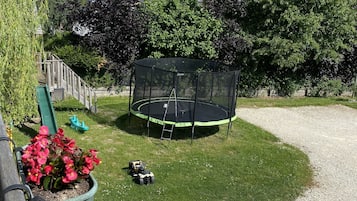 Enjoy a fun-filled day in the backyard with a trampoline and a beautifully maintained lawn.