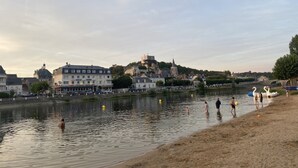Une vue sur la rivière, avec des bâtiments, une église et un château situés sur une colline.