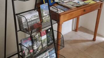 A black metal book rack with multiple shelves holding travel brochures and magazines.
