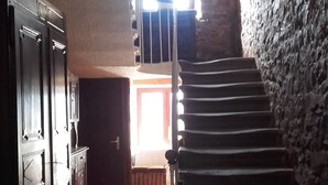 A staircase leading to a higher floor, a wooden cabinet, and a door with a window. - Auberge du coteau (Saint-Affrique)