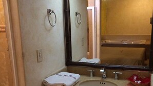 A small bathroom with a sink, mirror, and towel rack. - El Fuerte Motel (Acapulco)