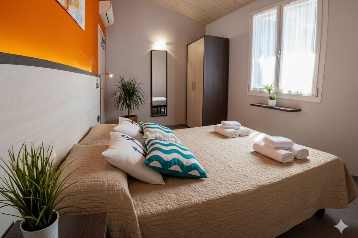 A bedroom with a bed, pillows, a potted plant, a mirror, a wardrobe, and a window with curtains.
