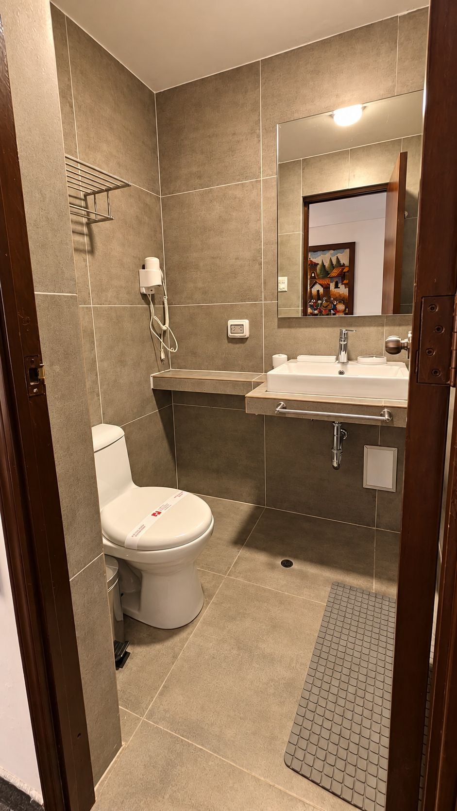 A modern bathroom with a toilet, sink, and shower area.