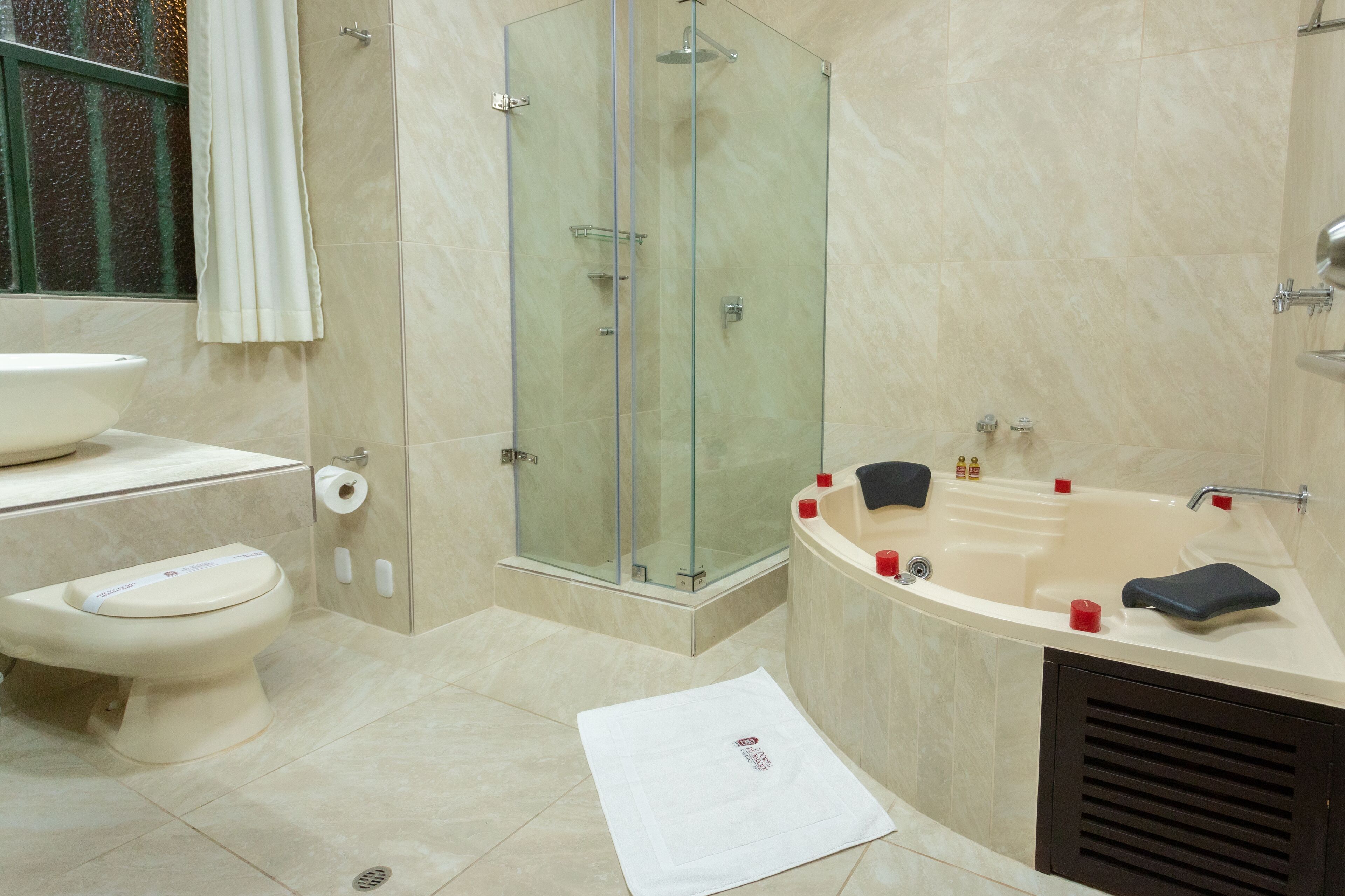 Un baño moderno con ducha de vidrio, una bañera independiente y un inodoro.