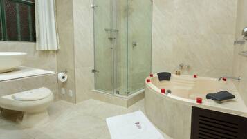 Un baño moderno con ducha de vidrio, una bañera independiente y un inodoro.
