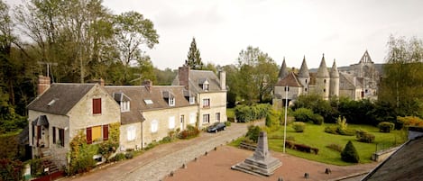 A cobblestone street leading to a historic building with a prominent tower.