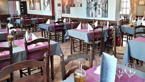 A restaurant with tables set for dining, chairs, and wine glasses. - Logis Hôtel les Terrasses (Longpont)