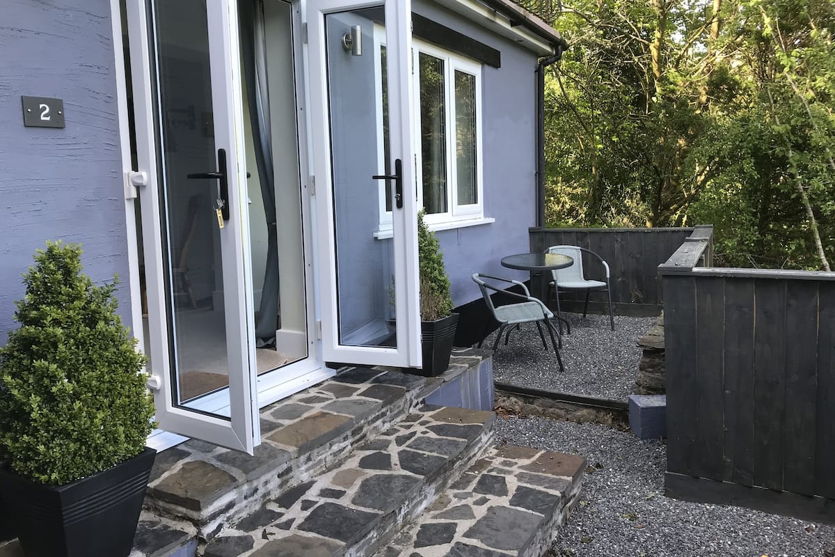 Un bâtiment à deux étages avec un escalier en pierre menant à un patio.