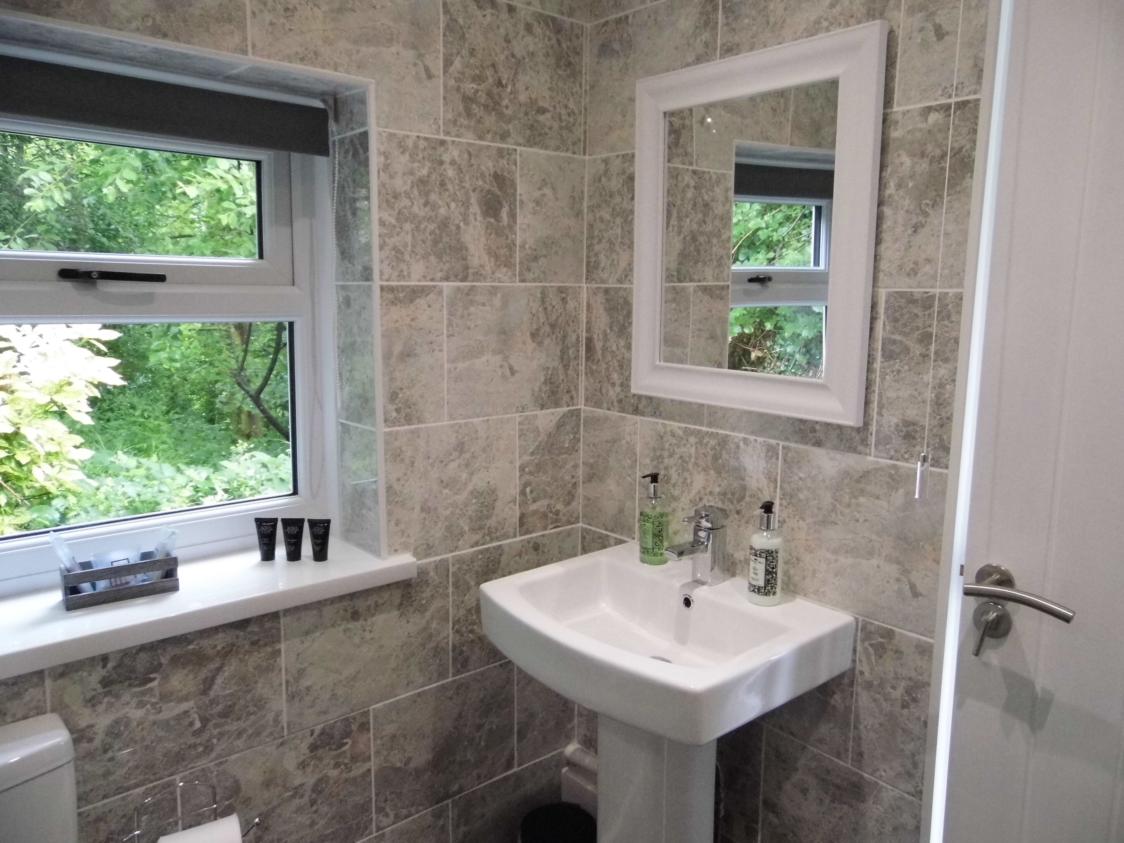 A bathroom with a sink, mirror, and window.