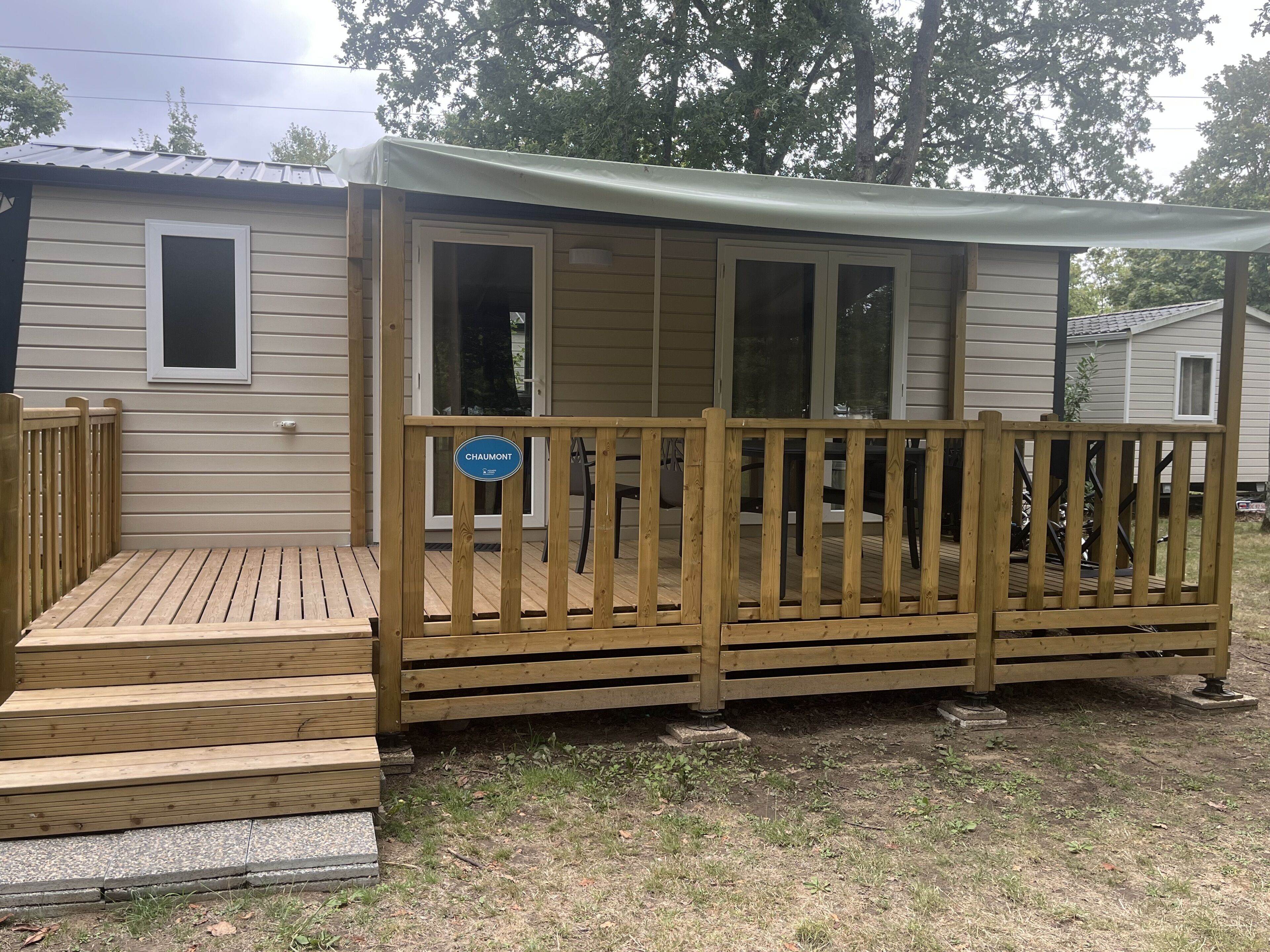 A wooden deck with a sign reading "CHAUMONT" leading to a covered porch area.