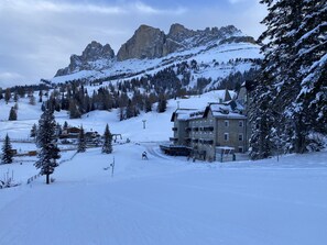 Ein schneebedeckter Berg mit einem Skiort, einschließlich einer Seilbahn und Sessellift.