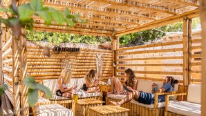 A bamboo pergola with seating areas, including cushioned chairs and benches. - Viajero Paracas Hostel (Paracas)
