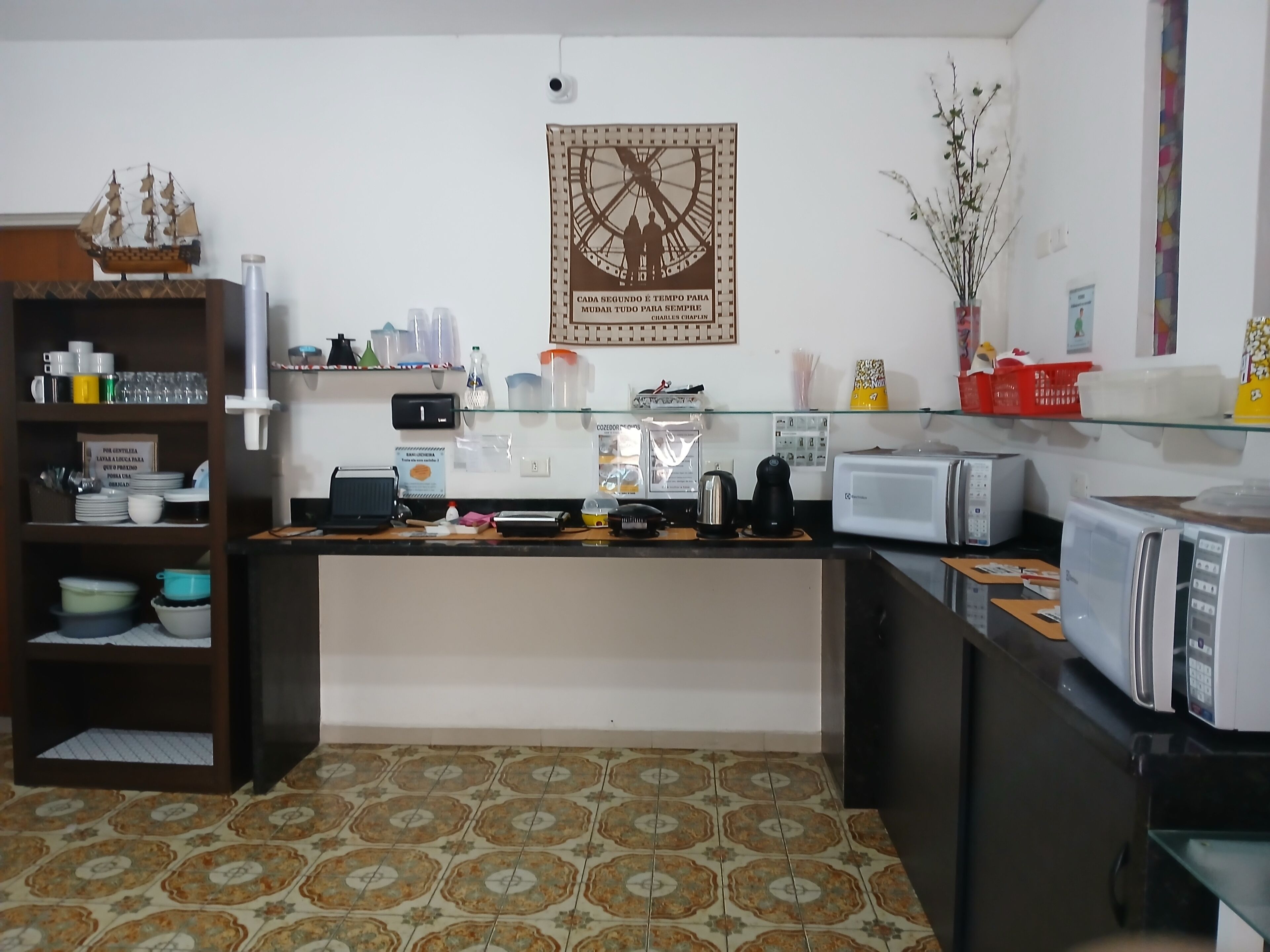 A kitchen with a coffee machine, toaster, and a clock on the wall.